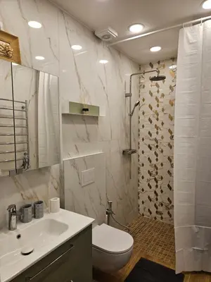 a white bathroom with a toilet and a sink at Uzupis Riverside Apartment in Vilnius