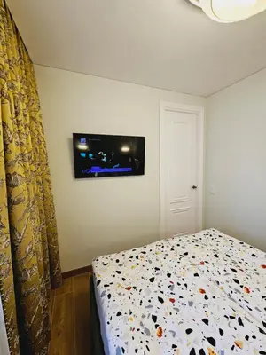 a bedroom with a bed with a tv on the wall at Uzupis Riverside Apartment in Vilnius
