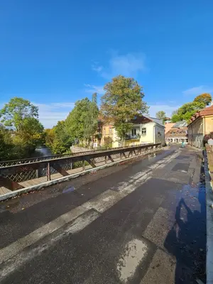 an empty street with a bridge over a river at Uzupis Riverside Apartment in Vilnius