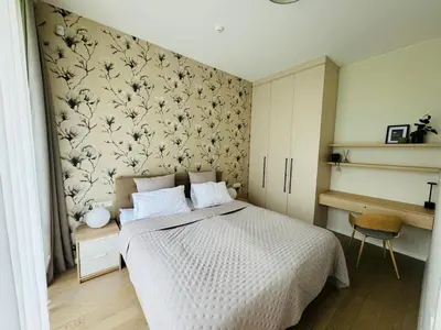 a bedroom with a bed with a floral wallpaper at Moon apartment in Druskininkai