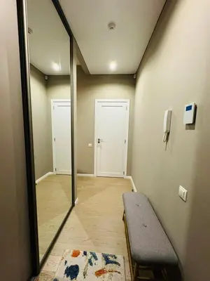 a room with a mirror and a bench and a door at Moon apartment in Druskininkai