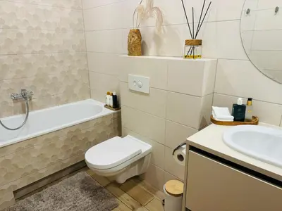 a white bathroom with a toilet and a sink at Moon apartment in Druskininkai