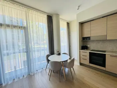 a kitchen with a table and chairs in a room at Moon apartment in Druskininkai