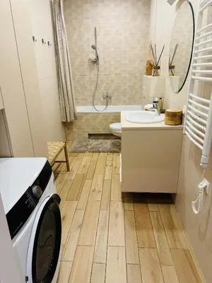 a bathroom with a washing machine on the floor at Moon apartment in Druskininkai