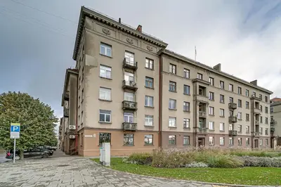 a large brick building with windows on a street at Arena Park Apartment in Kaunas