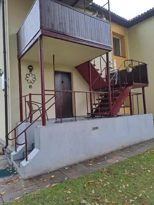 a building with a balcony with a staircase on it at Cosy studio apartment with the garden in Druskininkai