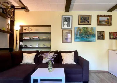 a living room with a couch and a table at Cosy studio apartment with the garden in Druskininkai