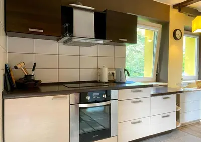 a kitchen with a stove top oven next to a window at Cosy studio apartment with the garden in Druskininkai