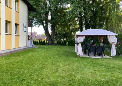 a gazebo with tables and chairs in a yard at Cosy studio apartment with the garden in Druskininkai