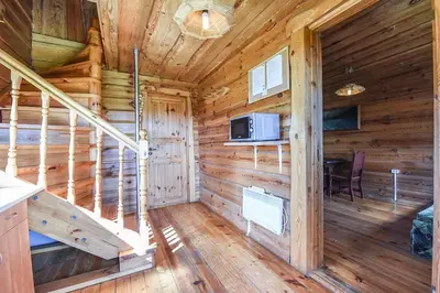 a log cabin with a staircase and a microwave at Svajonių Dvaras in Balninkai
