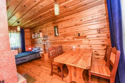 a wooden dining room with a wooden table and chairs at Svajonių Dvaras in Balninkai