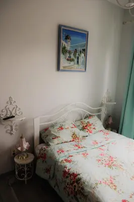 a bedroom with a white bed with flowers on it at Studio apartment in Jeruzalė in Vilnius