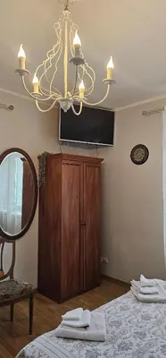 a chandelier in a bedroom with a bed and a mirror at Studio apartment in Jeruzalė in Vilnius
