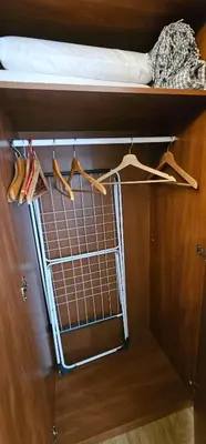a closet with a bed and hangers on a shelf at Studio apartment in Jeruzalė in Vilnius