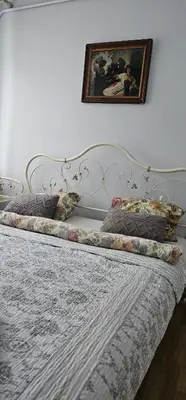 a white bed with pillows and a picture on the wall at Studio apartment in Jeruzalė in Vilnius