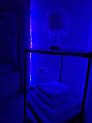 a room with a table with towels in a blue light at Kaunas Center Studio in Kaunas