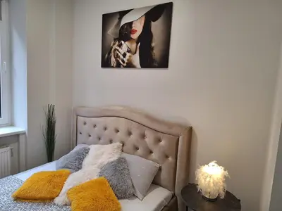 a bedroom with a bed with a picture on the wall at Kaunas Center Studio in Kaunas