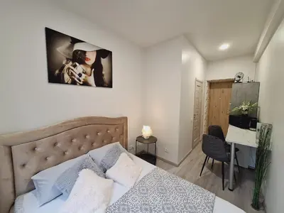 a bedroom with a bed and a desk in it at Kaunas Center Studio in Kaunas
