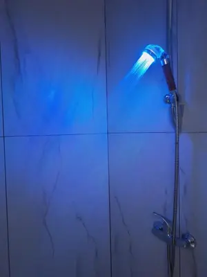 a shower with a blue light in a bathroom at Kaunas Center Studio in Kaunas