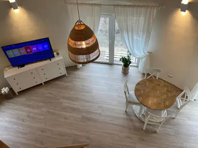 a living room with a table and a television at Kupolinis namelis in Kilova II