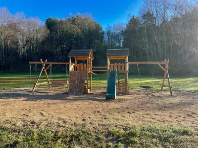 a playground with two play equipment in a field at Kupolinis namelis in Kilova II
