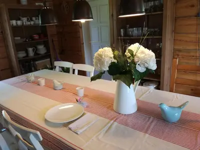 a table with a vase with white flowers on it at Lakeshore house in Dvarčėnai