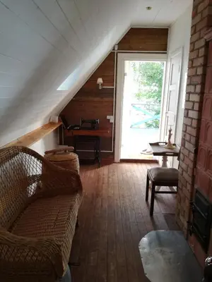 a living room with a couch and a piano at Lakeshore house in Dvarčėnai