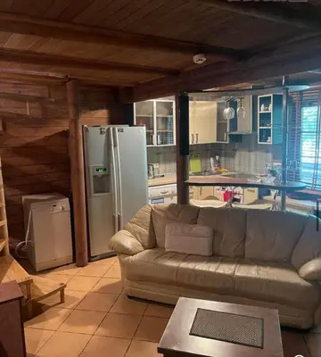 a living room with a couch and a refrigerator at Forest House in Pašvinės