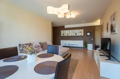 a living room with a table and a couch at Aqua House in Druskininkai
