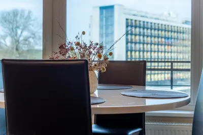 a table with chairs and a vase of flowers on it at Aqua House in Druskininkai
