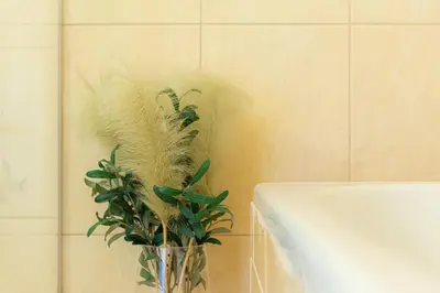 a vase with a plant sitting next to a tub at Aqua House in Druskininkai