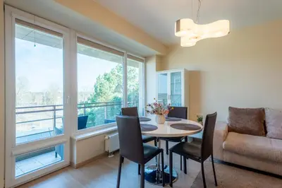 a living room with a table and chairs and a couch at Aqua House in Druskininkai