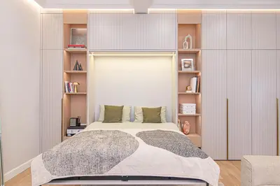 a bedroom with a large bed with book shelves at #stayhere - Authentic & Artsy Studio in Heart of Vilnius Old Town in Vilnius