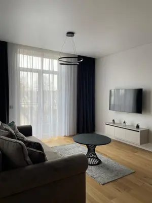 a living room with a couch and a table at Dineikos apartamentai in Druskininkai