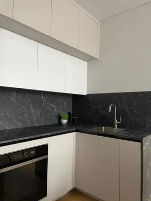 a kitchen with white cabinets and a sink at Dineikos apartamentai in Druskininkai