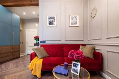 a red couch in a living room with a table at Charming apartment next to the Church of St Anne by Reside Baltic in Vilnius