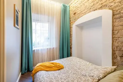 a bedroom with a bed with green curtains and a window at Charming apartment next to the Church of St Anne by Reside Baltic in Vilnius