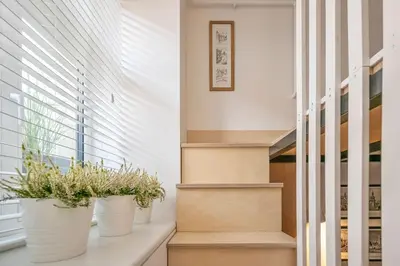 a staircase with three potted plants on a window sill at Stylish Apartment in Vilnius Old Town/ URBAN RENT in Vilnius