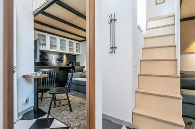 a staircase leading to a living room and a room with a table at Stylish Apartment in Vilnius Old Town/ URBAN RENT in Vilnius