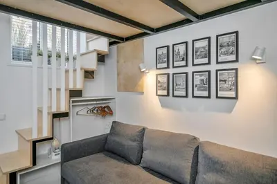 a living room with a couch and a staircase at Stylish Apartment in Vilnius Old Town/ URBAN RENT in Vilnius