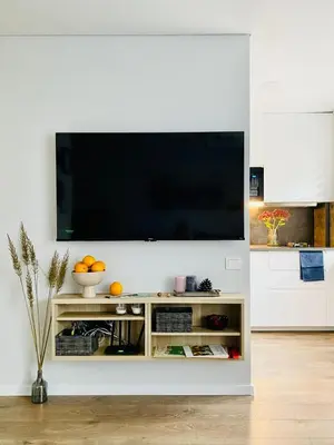 a living room with a television on a white wall at Alyvų tako studija in Alytus