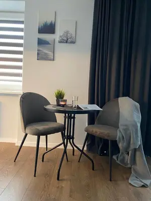 a table and two chairs in a living room at Alyvų tako studija in Alytus