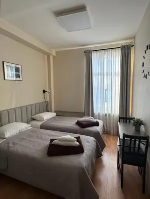 a hotel room with two beds and a window at Vaidoto 33 in Šiauliai