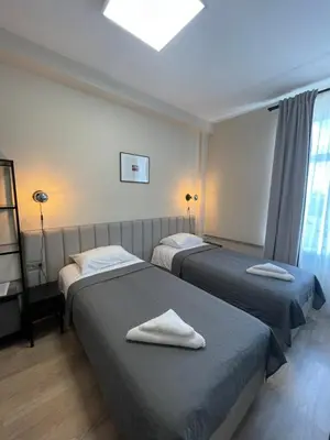 two beds in a hotel room with towels on them at Vaidoto 33 in Šiauliai