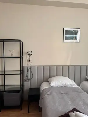 a white bedroom with a bed and a lamp at Vaidoto 33 in Šiauliai