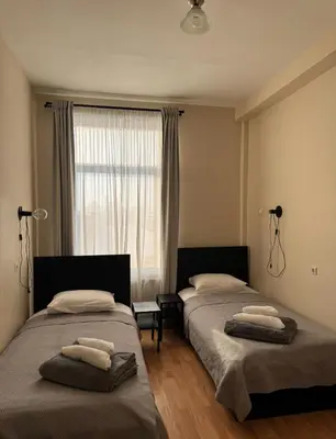 a bedroom with two beds and a window at Vaidoto 33 in Šiauliai