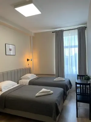 two beds in a hotel room with a window at Vaidoto 33 in Šiauliai