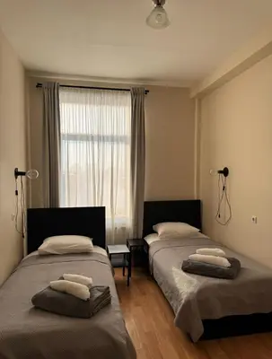 a bedroom with two beds and a window with towels at Vaidoto 33 in Šiauliai