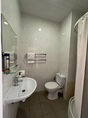 a white bathroom with a toilet and a sink at Vaidoto 33 in Šiauliai