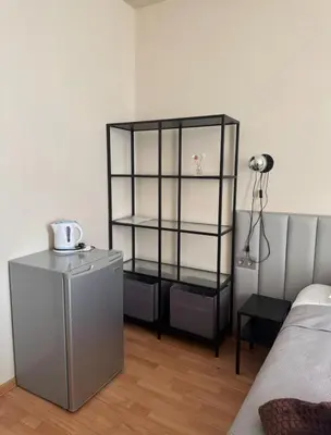 a black book shelf in a room next to a bed at Vaidoto 33 in Šiauliai